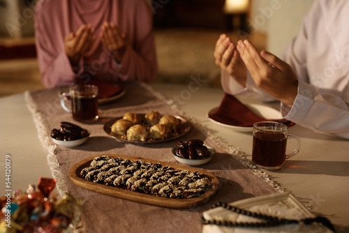 Fotografia Traditional Middle Eastern food with couple praying at dining table
