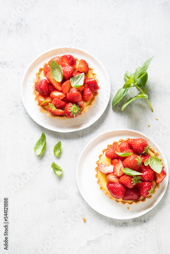 Delicious strawberry tarts with custard and fresh basil