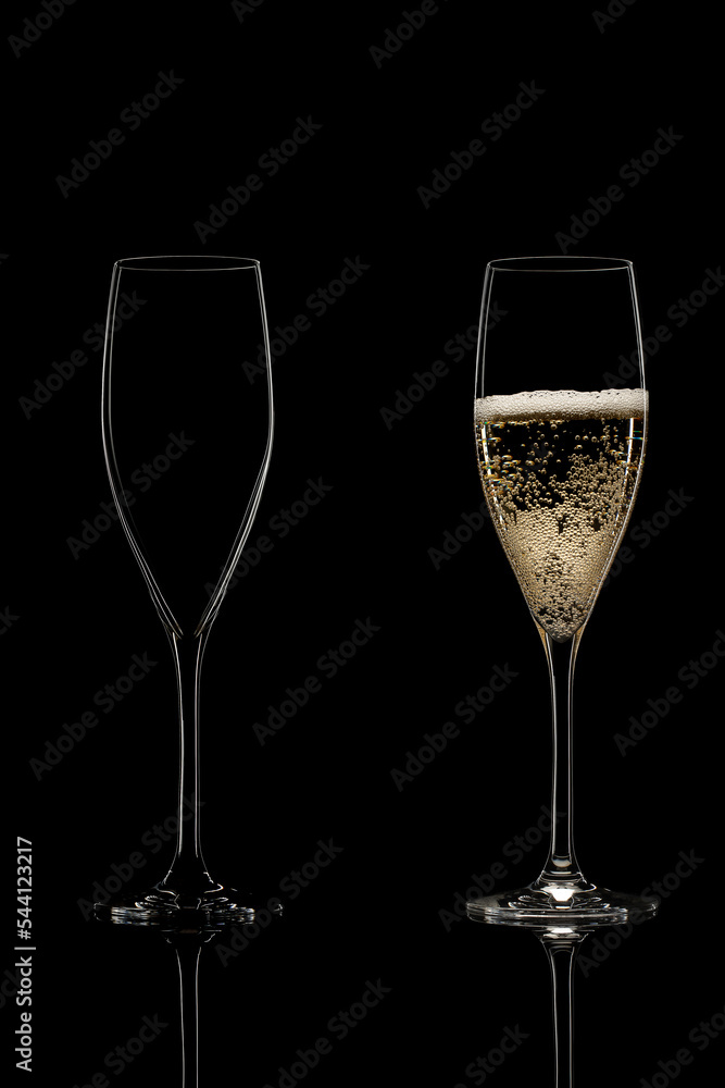 empty and full champagne glasses on black background empty and full champagne glasses on black background