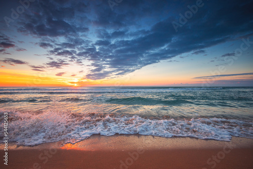 Beautiful cloudscape over the sea waves and beach