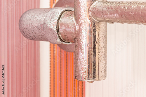 Wet heated towel rail covered with condensate. Close-up