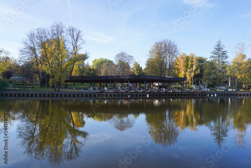 Pavilion for rest on the lake and reflection on the water in autumn public park