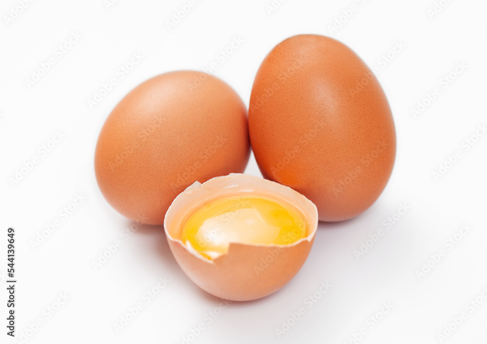 Raw fresh organic eggs with shell and yolk on white background. Raw fresh organic eggs with shell and yolk on white background.