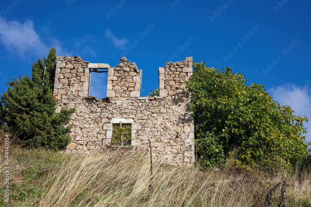 Ruined abandoned stonewall house rural environment nature sunny day blue sky Peloponnese Greece.