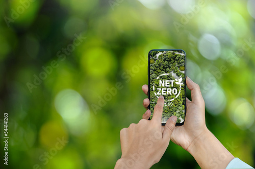 Businessman hands concept net zero icon on mobile screen environmental conservation in ECO sustainability for modern business related to environmental protection of nature ESG photo