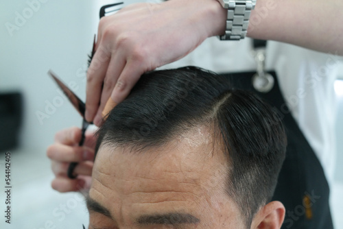 Close-up of a man's head having a haircut in a hairdressing salon