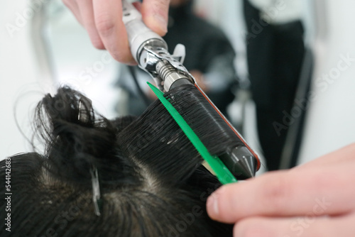 Close-up of a man's hair perming with a hairdressing tool