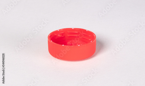 Isolated red plastic cap - Concept of pollution