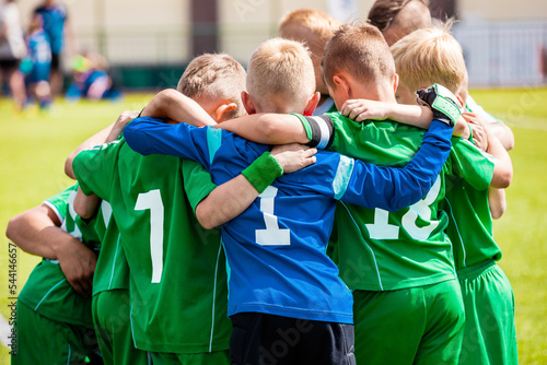Happy boys play team sport. Kids smiling in school sports team. Children together in huddle. Cheerful children boys players of school soccer team photo
