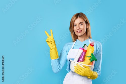 woman in gloves holding bucket of detergents and showing Ok