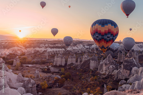 Colorful hot air balloons fly over the fabulous rocks in Cappadocia, Turkey.