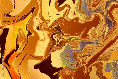 Abstract background of yellow-brown marble. Acrylic paint spreads freely and creates an interesting pattern. Background for the cover of a laptop, notebook. © Olirina