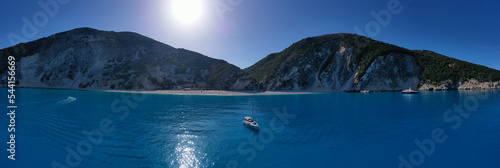 Aerial drone photo of sail boat anchored in paradise beach of Myrtos with crystal clear turquoise sea surrounded by steep cliffs