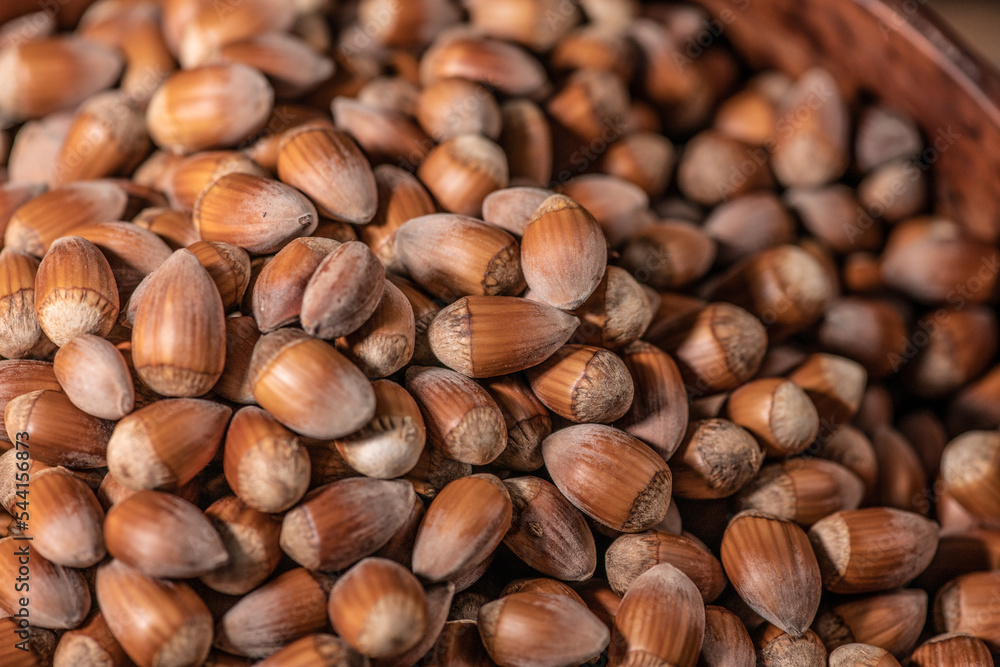 Close up on a pile of Hazelnuts in a wooden bowl Close up on a pile of Hazelnuts in a wooden bowl