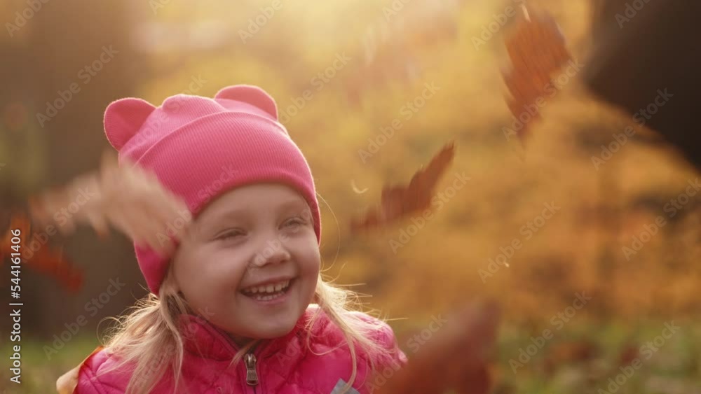 Mother and daughter having fun at autumn golden forest, toddler girl