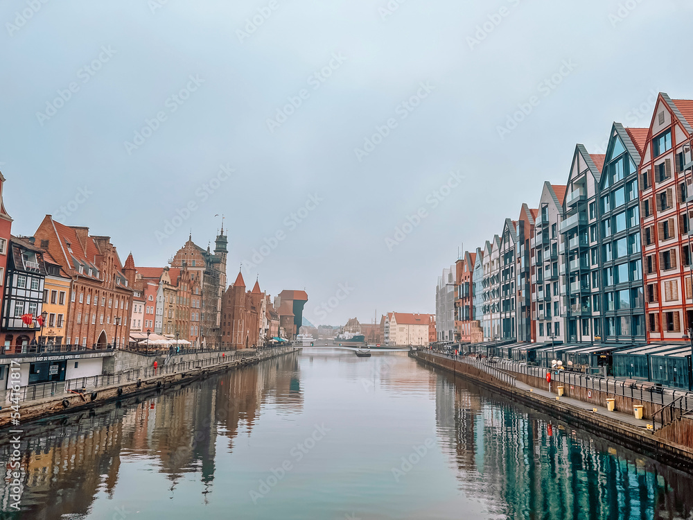 Panorama of Gdansk with beautiful old town over Motlawa river at fog, Poland.