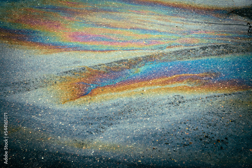 Oil gasoline Rainbow leak flows into the sewer in the car parking