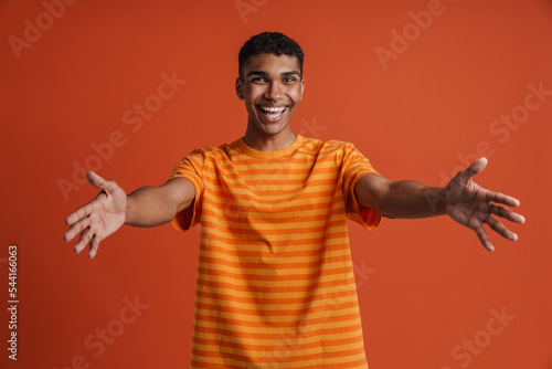 Young black man smiling and stretching his arms at camera