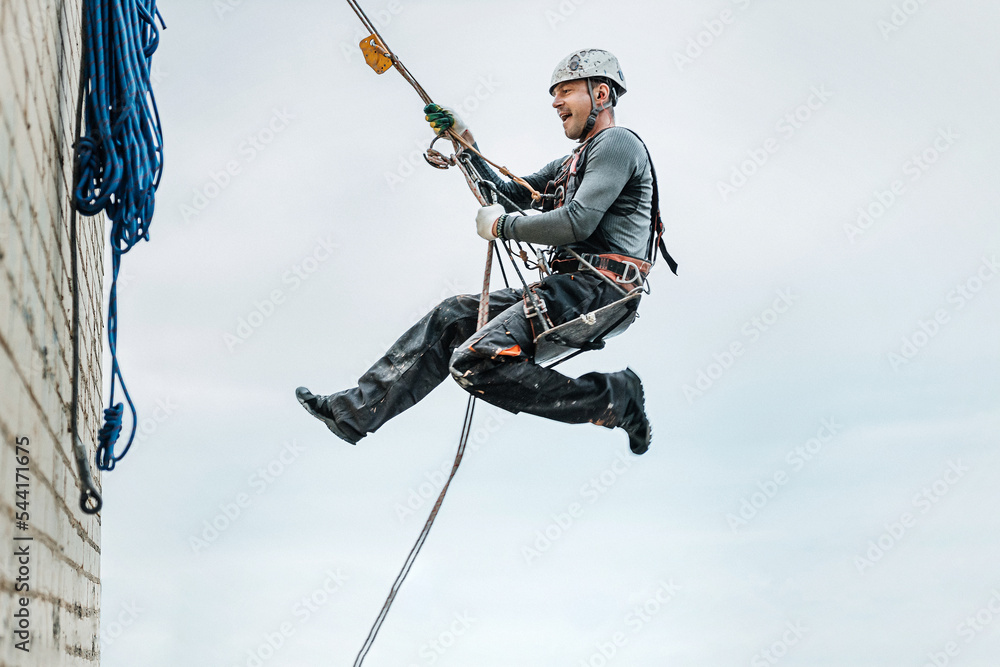 Male worker rope access industrial working at height tank oil wearing  harness, helmet safety equipment rope Stock Photo