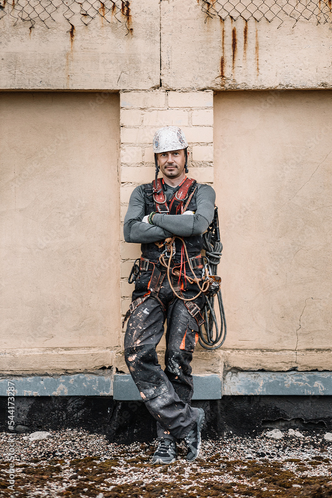 Fototapeta premium Male worker rope access industrial working at height tank oil wearing harness, helmet safety equipment rope