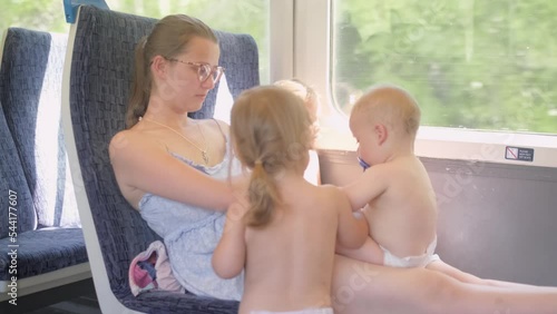 Very Hot weatherin Summer Traffic. Family with many little children Traveling by train. Tired Mother with kids on a trip. Tourism on vacation, travel around the world. Matherhood, Transport photo