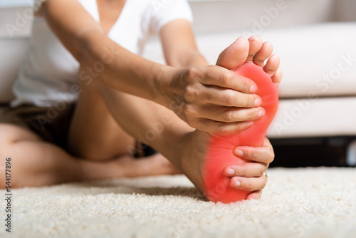 Foot pain, Asian woman feeling pain in her foot at home, female suffering from feet ache use hand massage relax muscle from soles in home interior, Healthcare problems and podiatry medical concept © sorapop