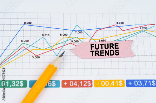 On business charts there is a pencil and an arrow sticker with the inscription - FUTURE TRENDS