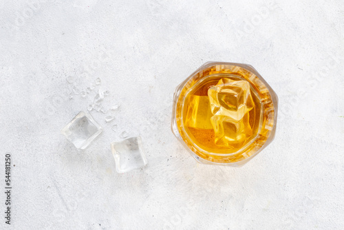 Glass of whiskey or brandy with ice. Strong alcohol background