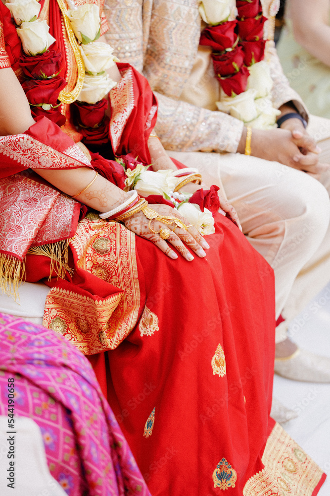 Naklejka premium Indian man and woman in festive traditional dress and costume, sitting together during wedding ceremony