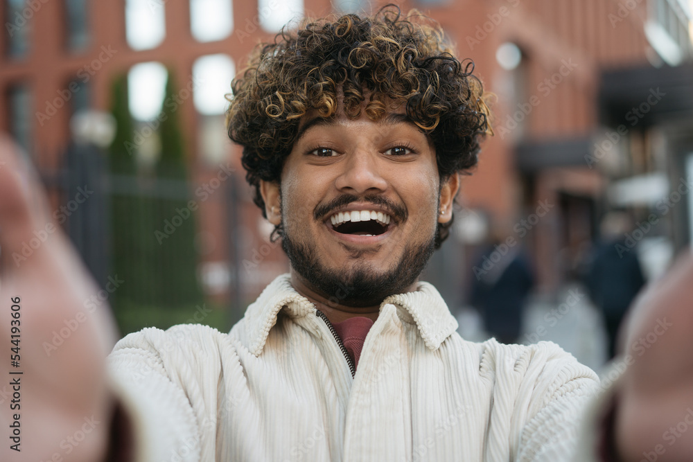Smiling Indian man tourist taking selfie, having video call on the street. Happy stylish asian influencer recording video, communication online, having fun outdoors Smiling Indian man tourist taking selfie, having video call on the street. Happy stylish asian influencer recording video, communication online, having fun outdoors