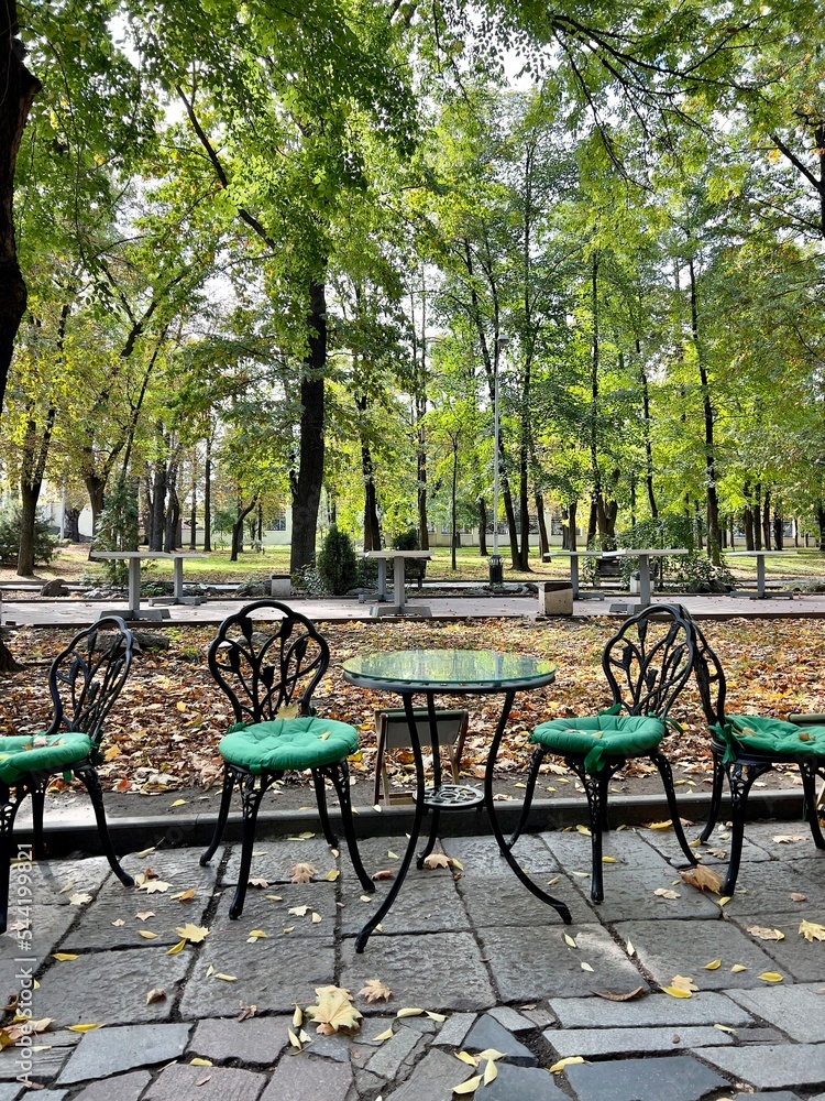 green chairs and tables in the park