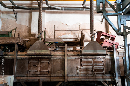 Murano glass blowing factory. Workers put iron rod in furnace to make glass malleable.
Artist shaping hot glass into a figurine with gas flames. Artisan making glass vases and sculptures. Venice wint