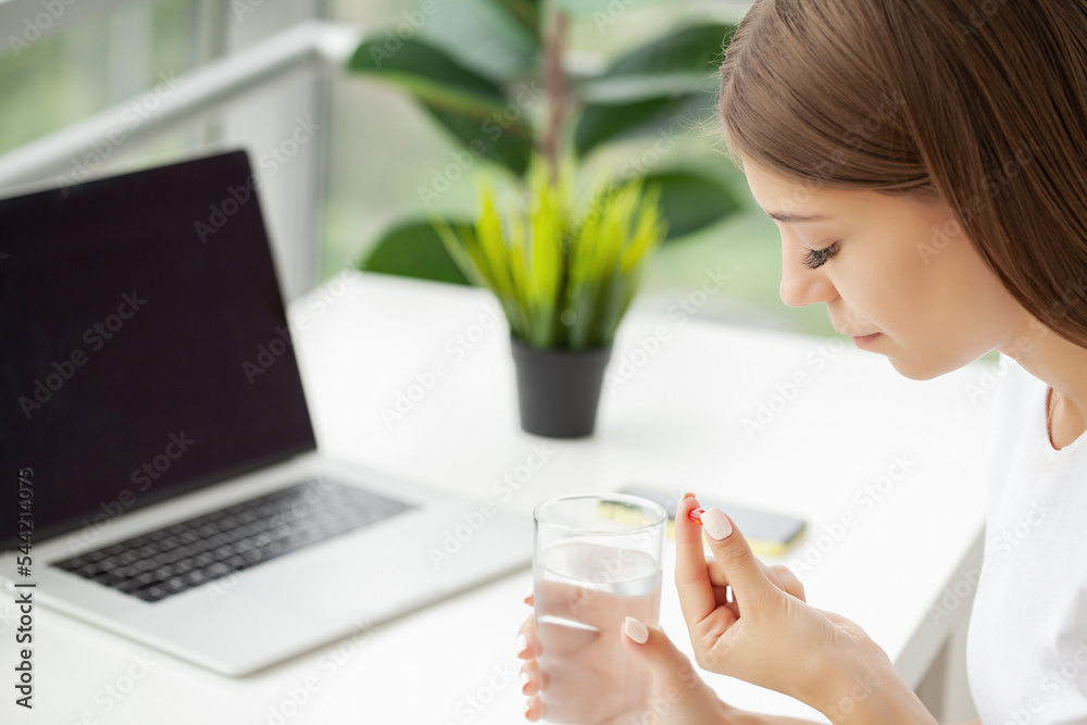 Healthy young woman holding pill glass of water Healthy young woman holding pill glass of water