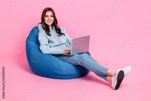 Full body photo of cheerful lovely lady sit comfort bag use wireless netbook isolated on pink color background