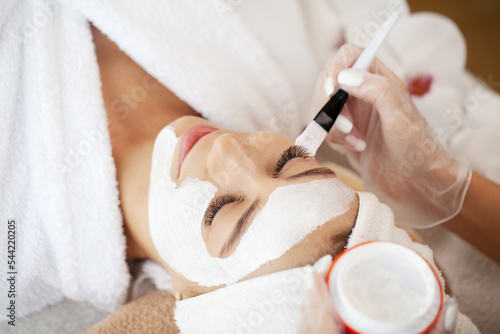Woman getting facial care by beautician at spa salon