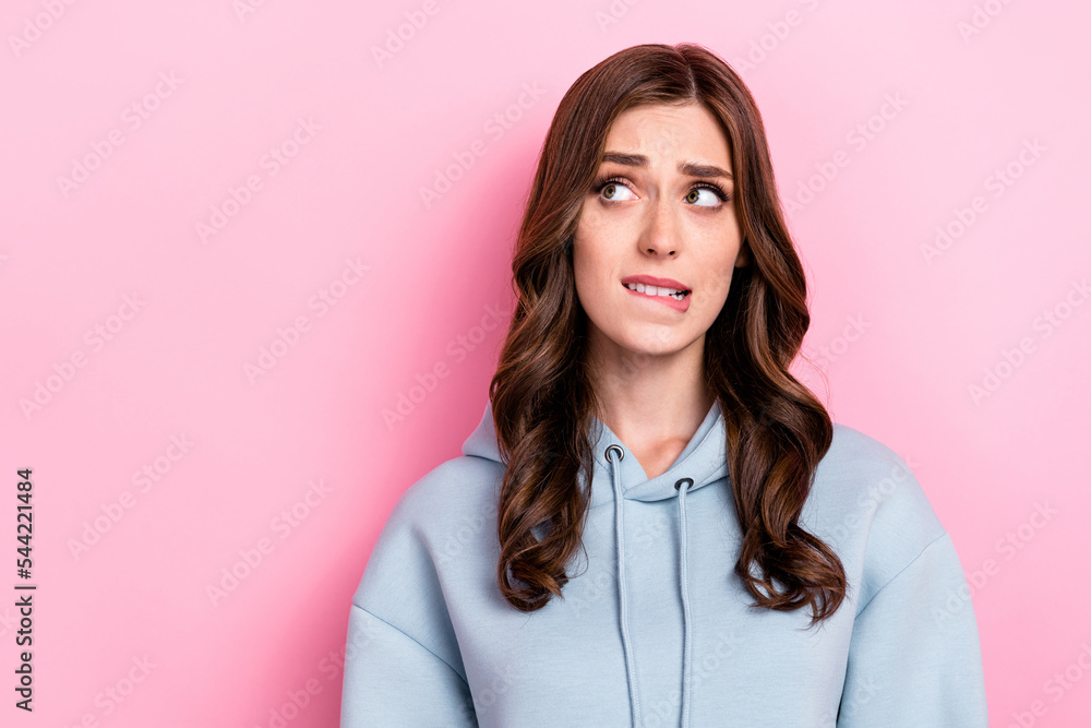 Photo of doubtful unsure girl dressed grey sweatshirt biting lip looking empty space isolated pink color background - obrazy, fototapety, plakaty 