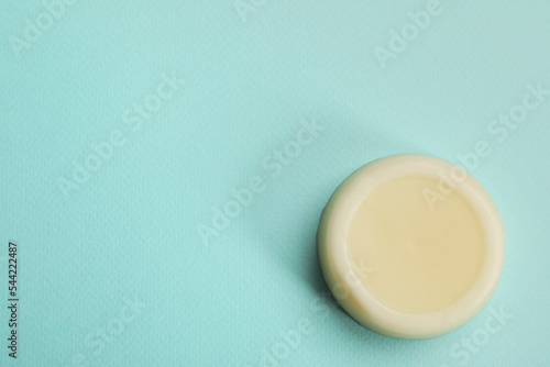 Solid shampoo bar on turquoise background  top view. Space for text