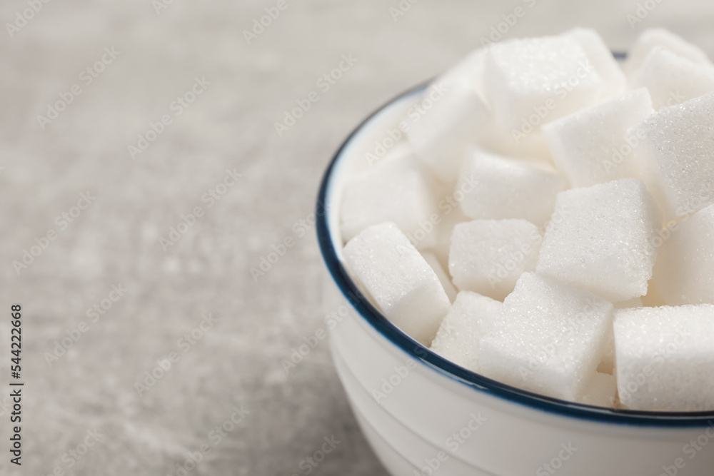 Bowl with sugar cubes on grey table, closeup. Space for text Bowl with sugar cubes on grey table, closeup. Space for text