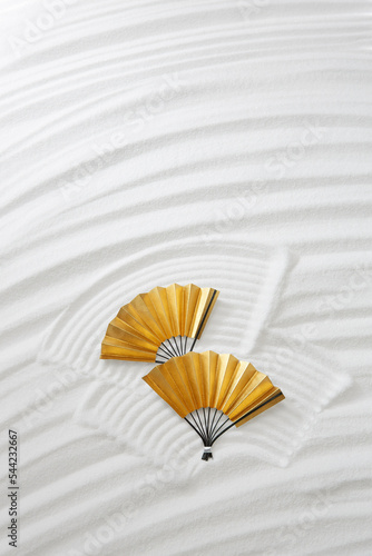 白砂で描いた曲線と金の扇子