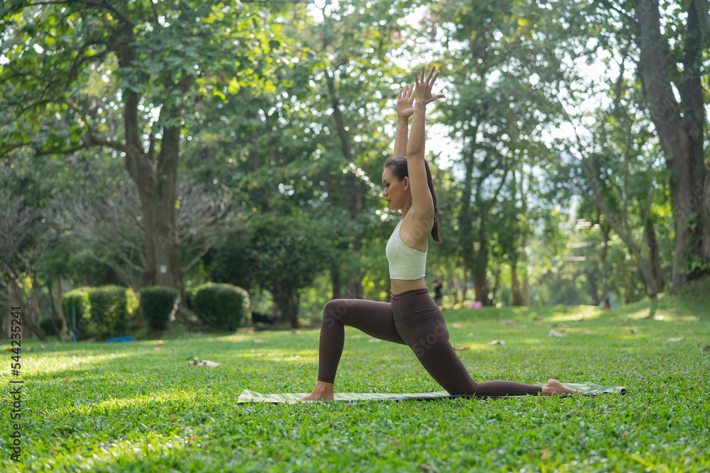 Asian slim woman exercise alone in the park, Tired from a workout, Play yoga concept Asian slim woman exercise alone in the park, Tired from a workout, Play yoga concept