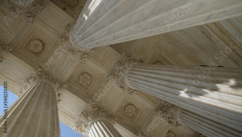 Obraz na plátne Looking up at the top of Corinthian columns in front of US Supreme Court in Washington, DC, showing power over people and business