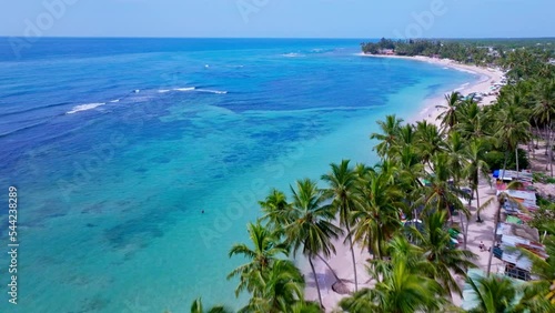 Beautiful Aerial View Of Playa Guayacanes Surrounded By Clear Blue Sea And White Sand Lined With Palm Trees In Santo Domingo, Dominican Republic. - Drone Aerial Shot photo