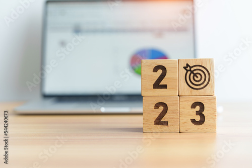 2023 Year block with dartboard icon against computer laptop background. Goal, Target, Resolution, strategy, plan, Action, mission, motivation, and New Year start concepts