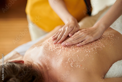Masseuse Massaging Back of Woman