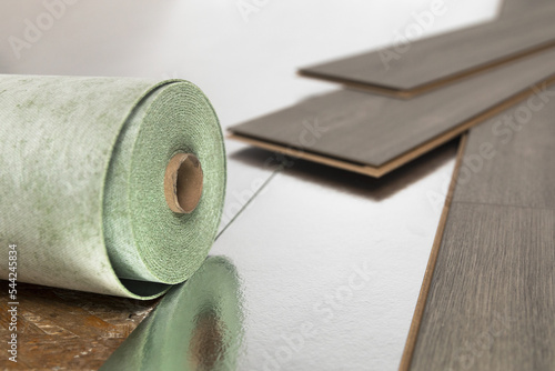 Installation of floating floor, underlay with sheets of laminate. Home improvement concept.
