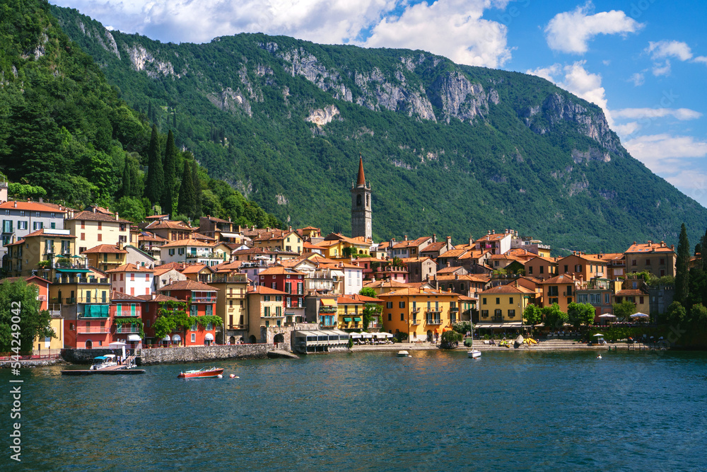 Beautiful panorama of Varenna, one of the most famous and picturesque towns in Lombardy, Italy,  with Alpine views, Italian villas overlooking the water, and botanical gardens along the shore.