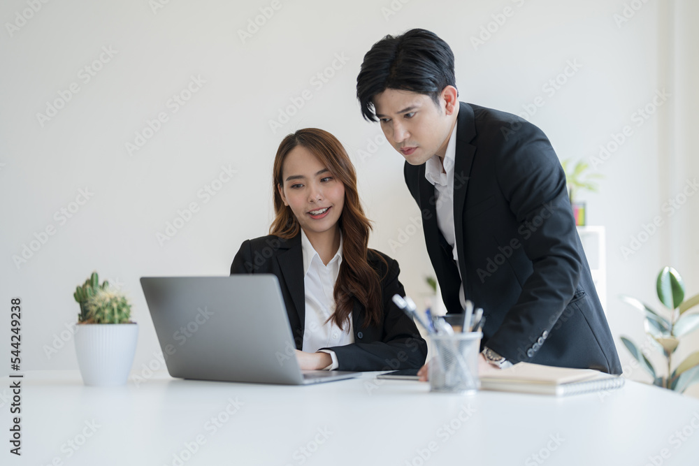 Business people discuss business ventures together by viewing information through a notebook Business people discuss business ventures together by viewing information through a notebook