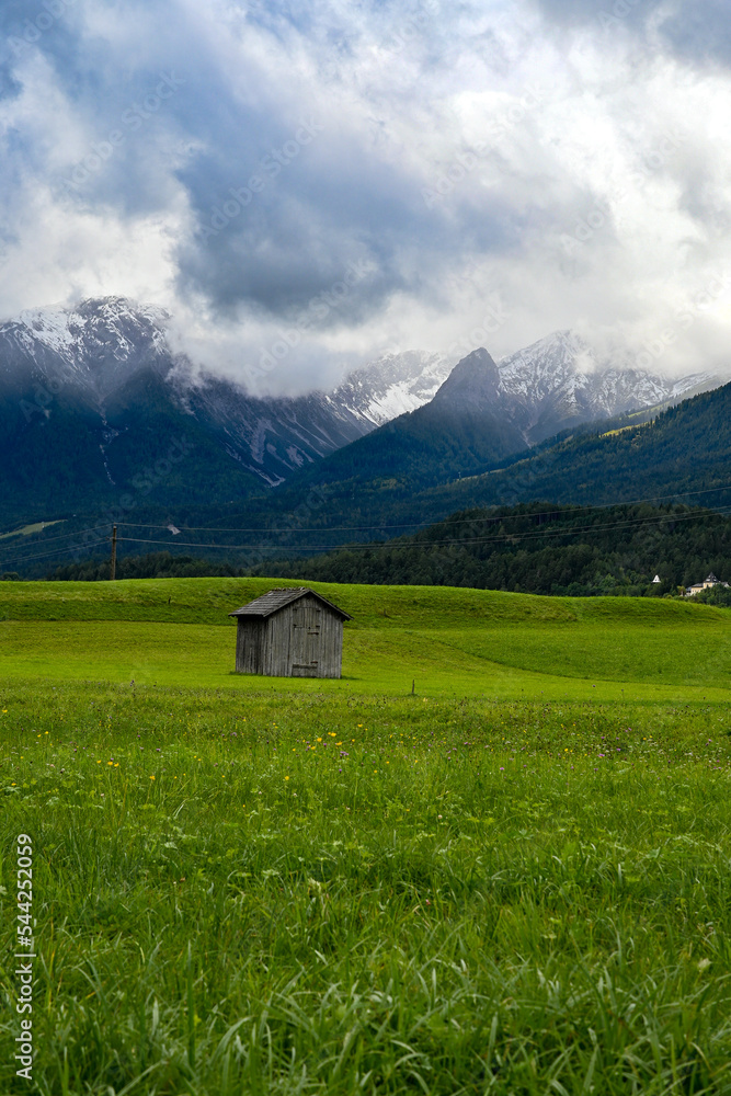 Alter Heustadl auf einer Wiese im Tal bei Imst, mit Blick auf die umliegende Berge Muttekopf