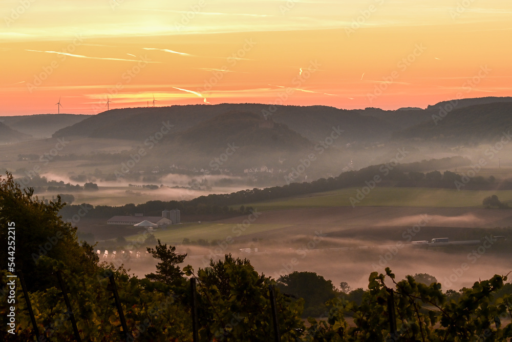 Bezaubernder Sonnenaufgang am frühen Morgen über Hammelburg, Nebel liegt im Tal, Elfershausen bei Bad Kissingen, Franken, Bayern, Deutschland