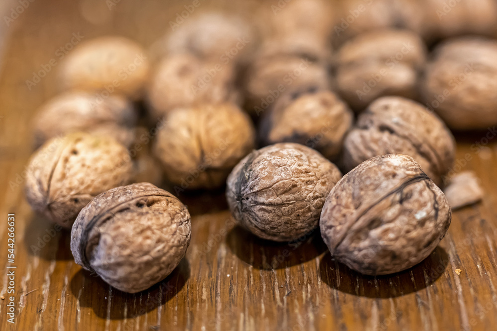 Heap of unpeeled walnuts on wooden table Heap of unpeeled walnuts on wooden table